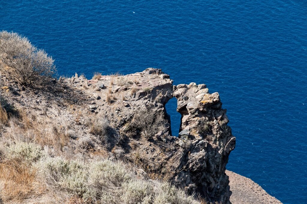 The natural rock arch of Skaros above the deep blue Aegean