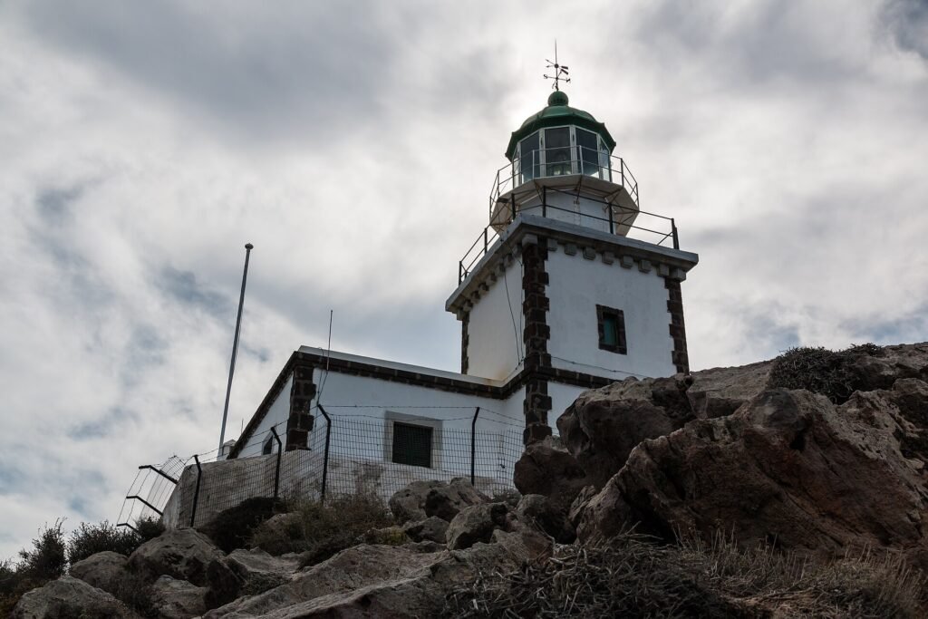 Akrotiri lighthouse on the rocks at the southern tip of Santorini